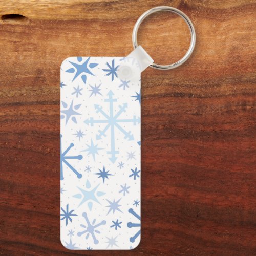 A whimsical flurry of blue snowflakes on white keychain