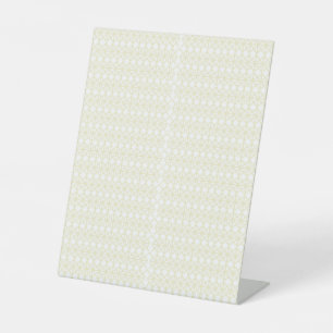 a white and gold geometric pattern pedestal sign