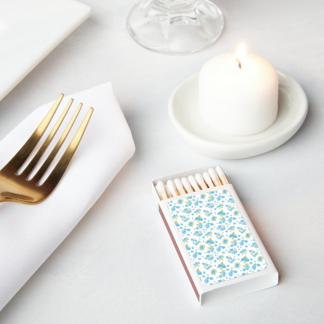 a white background with blue flowers and green lea matchboxes (Insitu)
