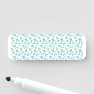 a white background with blue flowers and green lea name tag