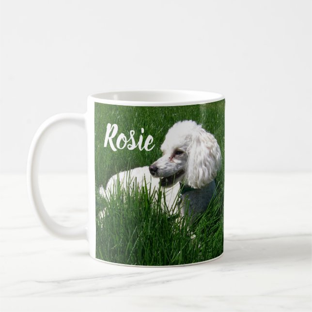 A White Poodle Resting in Lush Green Grass Coffee Mug (Left)