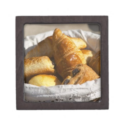 A wicker breakfast basket with croissants and keepsake box