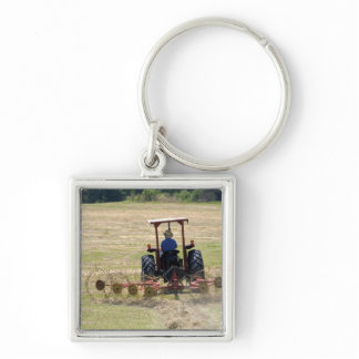 A young boy driving a tractor harvesting keychain