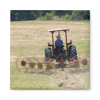 A young boy driving a tractor harvesting magnet