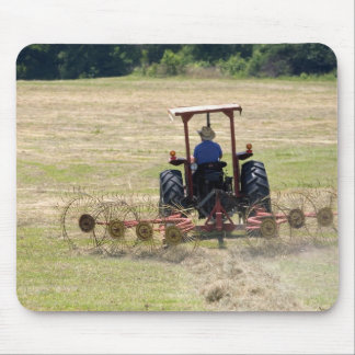 A young boy driving a tractor harvesting mouse pad