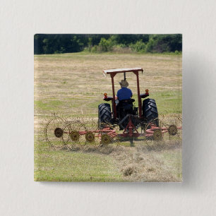 A young boy driving a tractor harvesting pinback button