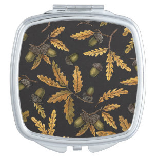 Acorns and oak leaves on black compact mirror