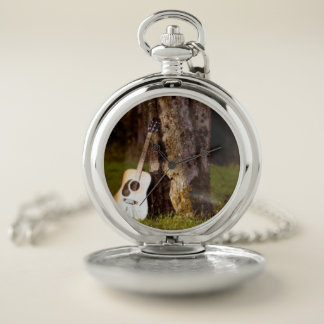 acoustic guitar against tree pocket watch