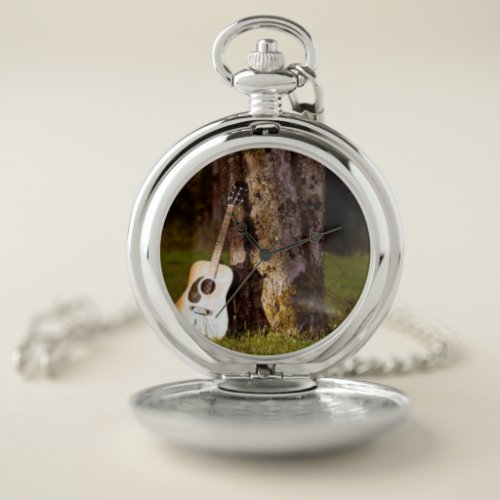 acoustic  guitar against tree pocket watch