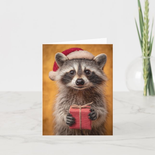 Adorable Raccoon in a Santa Hat Holding a Present Holiday Card (Front)