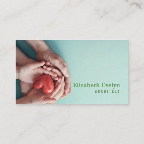 Adult and child hands holding red heart on aqua business card