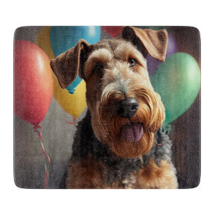 Airedale dog with cake and balloons cutting board