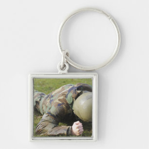 Airman crawls through a wet field keychain