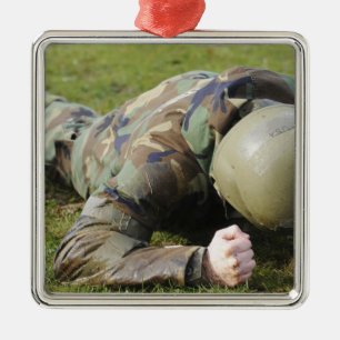 Airman crawls through a wet field metal ornament