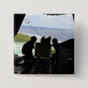 Airmen push out a pallet of donated goods pinback button