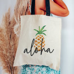 Aloha Tropical Watercolor Pineapple Tote Bag<br><div class="desc">Cute tote bag design features a pineapple illustration,  the traditional symbol of hospitality,  in sheer,  pretty watercolors. The Hawaiian greeting "Aloha" is overlaid in handwritten lettering. Makes a great welcome bag or favor for Hawaii weddings or destination weddings!</div>
