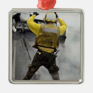 An aircraft director signals a F/A-18C Hornet Metal Ornament
