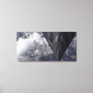 An F-117A Nighthawk flies high over the mountai Canvas Print