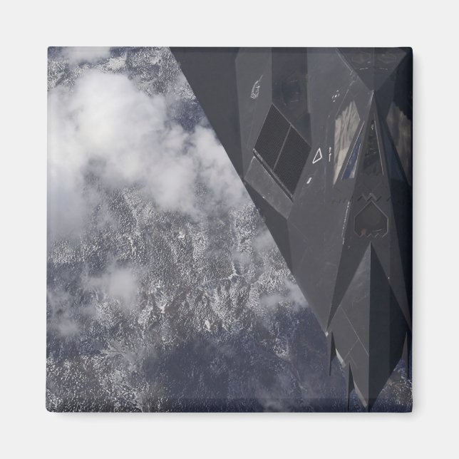 An F-117A Nighthawk flies high over the mountai Magnet (Front)