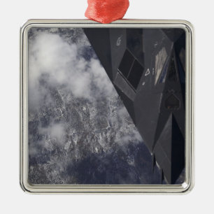 An F-117A Nighthawk flies high over the mountai Metal Ornament