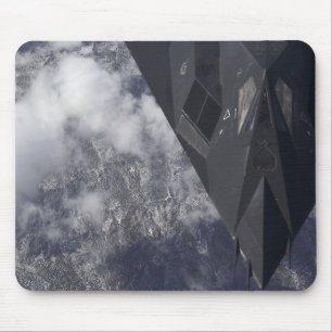 An F-117A Nighthawk flies high over the mountai Mouse Pad