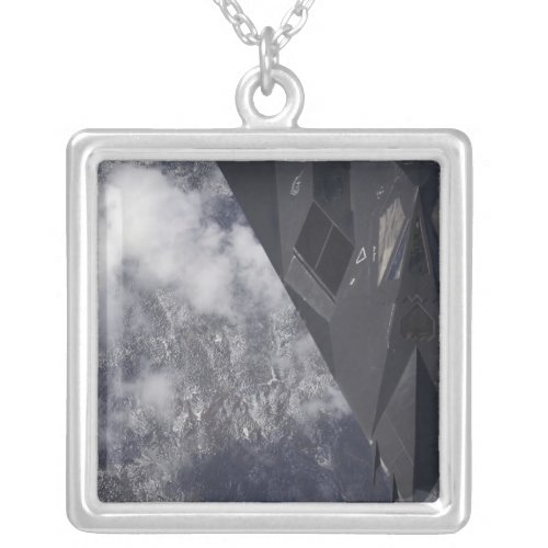 An F_117A Nighthawk flies high over the mountai Silver Plated Necklace