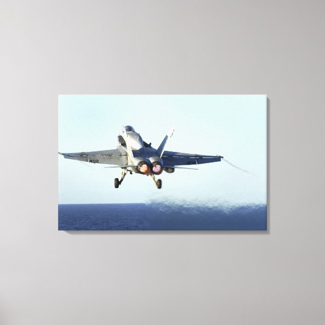 An F/A-18C Hornet launches from the flight deck Canvas Print (Front)