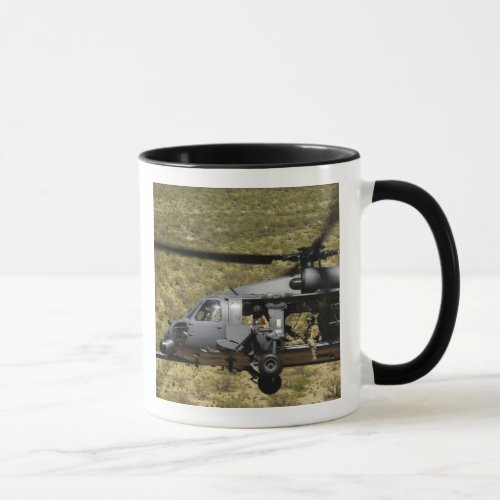 An HH_60 Pave Hawk flies over the desert Mug