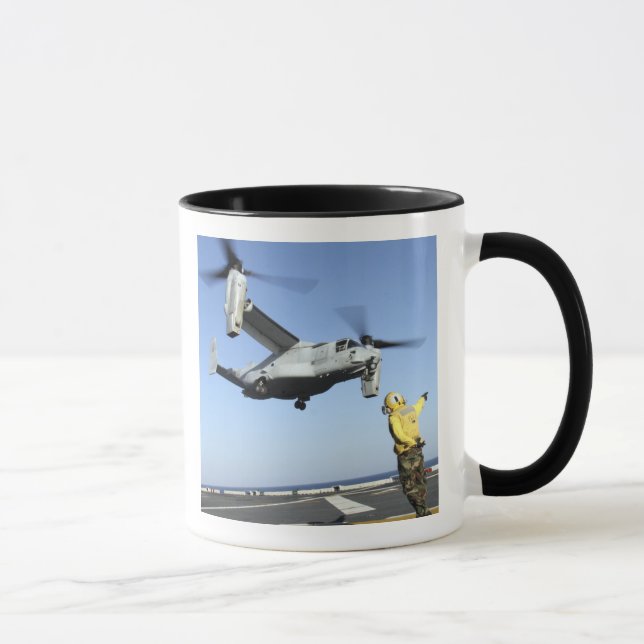 An MV-22 Osprey launches from the USS Nassau Mug (Right)