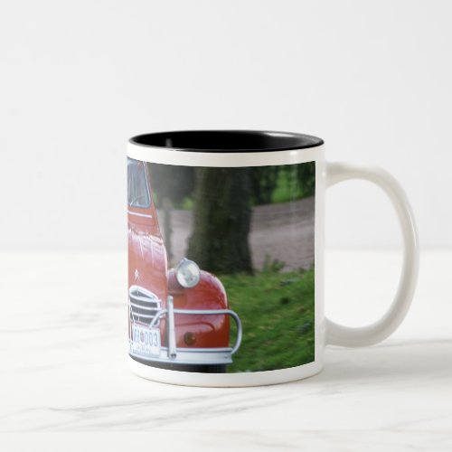 An old red Citroen 2CV car with a smiling woman Two_Tone Coffee Mug