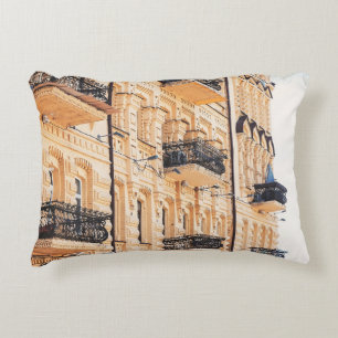 An old yellow house with wrought-iron balconies. f accent pillow