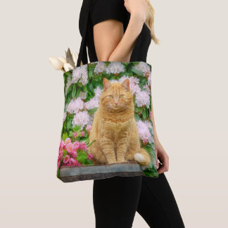 An Orange Cat in a Garden with Pink Spring Flowers Tote Bag