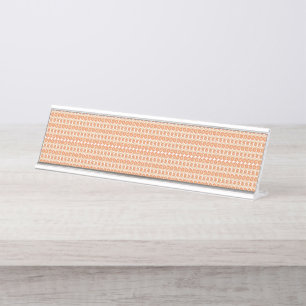 An orange rug with a textured pattern lies flat on desk name plate