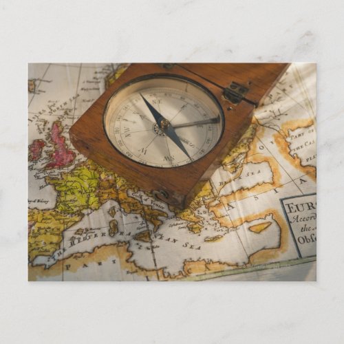 Antique compass on map postcard