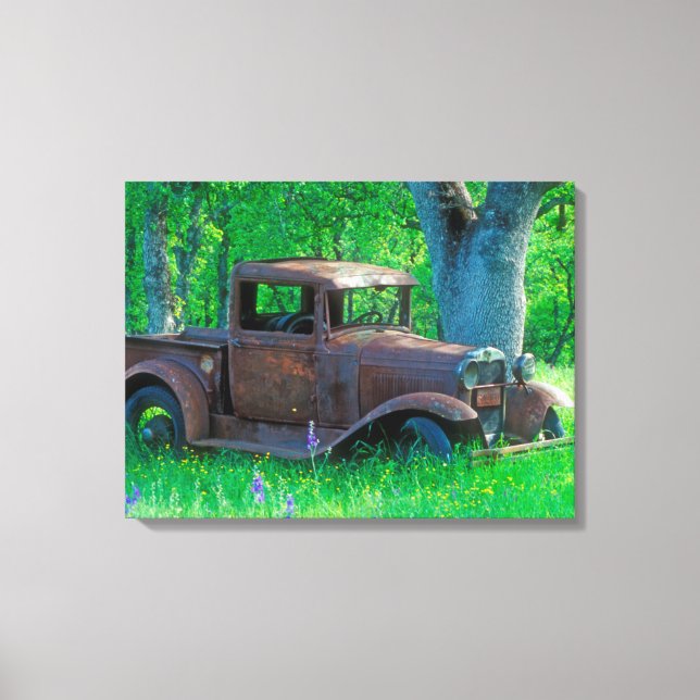 Antique rusted truck in a meadow canvas print (Front)