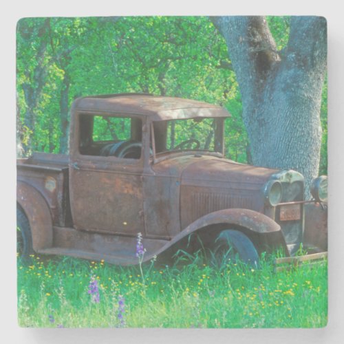 Antique rusted truck in a meadow stone coaster