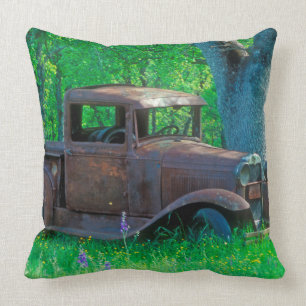 Antique rusted truck in a meadow throw pillow