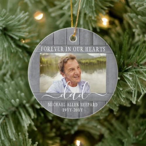 Any Text 2 Photo Memorial Simple Gray Faux Wood Ceramic Ornament - Honor a departed loved one for the holidays with a custom photo faux wood round ceramic Christmas ornament. All text and images on this template are simple to personalize. "Forever in our hearts" can be changed to "in loving memory of," "an angel in heaven" or other wording. (IMAGE PLACEMENT TIP: An easy way to center a photo exactly how you want is to crop it before uploading to the Zazzle website.) The modern farmhouse style design features a rustic grey faux wood border, elegant handwritten style script calligraphy, typewriter typography name and years, and two images of your choice. This unique & modern sympathy keepsake makes a thoughtful funeral remembrance gift idea and adds a stylish touch to Xmas home decorations. It's an elegant way to pay tribute to a family member or friend who has passed away.