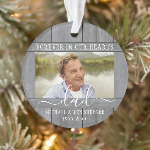 Any Text 2 Photo Memorial Simple Gray Faux Wood Ornament - Honor a departed loved one for the holidays with a custom photo faux wood round acrylic Christmas ornament. All text and images on this template are simple to personalize. "Forever in our hearts" can be changed to "in loving memory of," "an angel in heaven" or other wording. (IMAGE PLACEMENT TIP: An easy way to center a photo exactly how you want is to crop it before uploading to the Zazzle website.) The modern farmhouse style design features a rustic grey faux wood border, elegant handwritten style script calligraphy, typewriter typography name and years, and two images of your choice. This unique & modern sympathy keepsake makes a thoughtful funeral remembrance gift idea and adds a stylish touch to Xmas home decorations. It's an elegant way to pay tribute to a family member or friend who has passed away.