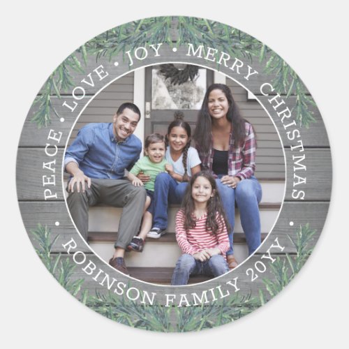 Any Text Photo Modern Farmhouse Greenery Grey Wood Classic Round Sticker - Add a stylish finishing touch to holiday card envelopes and Christmas gifts with these custom photo modern farmhouse style round stickers. All text on this template is simple to customize to include any wording, such as Merry Christmas, Happy Holidays, Seasons Greetings, New Year Cheers etc. (IMAGE PLACEMENT TIP:  An easy way to center a photo exactly how you want is to crop it before uploading to the Zazzle website.) As an option, change text to name and address for use as chic round return address envelope seals. Design features a rustic grey wood background, festive watercolor pine greenery,  minimalist typography, and one picture of your choice.