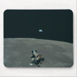 Apollo Lunar Lander and Earthrise Over Moon Mouse Pad<br><div class="desc">The cramped command module served as a temporary home, framing a breathtaking vista. In the foreground, the delicate spider-like Lunar Module dangled, awaiting its descent. Beyond it stretched the stark, cratered moonscape, its horizon curving dramatically. But stealing the show was Earth, a vibrant blue marble suspended in the black abyss,...</div>
