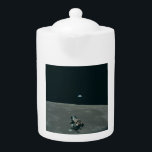 Apollo Lunar Lander and Earthrise Over Moon     Teapot<br><div class="desc">The cramped command module served as a temporary home, framing a breathtaking vista. In the foreground, the delicate spider-like Lunar Module dangled, awaiting its descent. Beyond it stretched the stark, cratered moonscape, its horizon curving dramatically. But stealing the show was Earth, a vibrant blue marble suspended in the black abyss,...</div>
