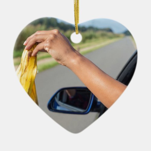 Arm dropping peel of banana out car window ceramic ornament