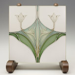 Art Nouveau Lily Elegance Ceramic Tile<br><div class="desc">This Art Nouveau-inspired ceramic tile is an elegant tribute to the sophisticated curves and naturalistic style of the early 20th century. A pair of symmetrical lily blooms rise gracefully, their ivory and cream petals contrasting against the muted sage and olive green leaves that curl and flow with sinuous lines. The...</div>