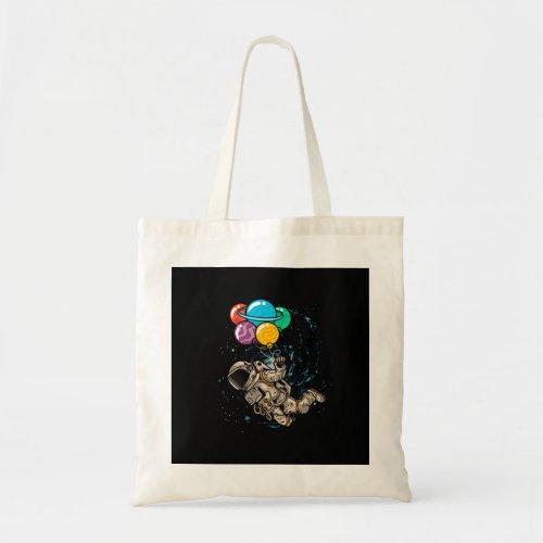 astronaut floating in space using planet balloon tote bag
