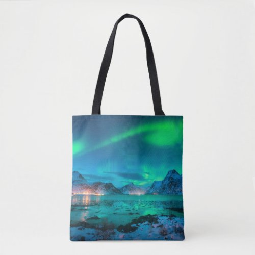 Aurora borealis over the sea coast snowy mountain tote bag