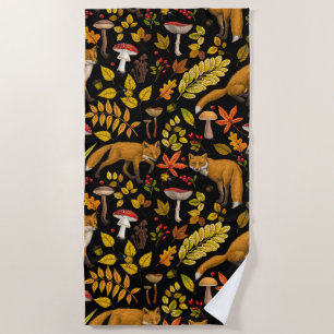 Autumn foxes on black beach towel