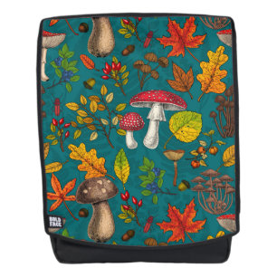 Autumn mushrooms, leaves, nuts and berries on blue backpack