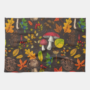 Autumn mushrooms, leaves, nuts and berries on dark kitchen towel