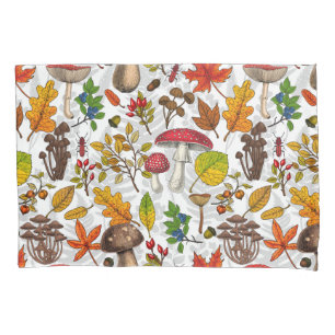 Autumn mushrooms, leaves, nuts and berries on whit pillow case